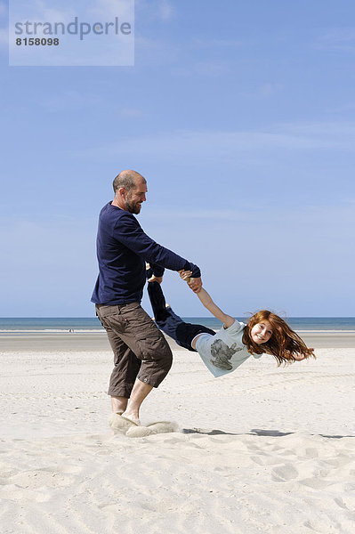 France  Father with daughter having fun at beach