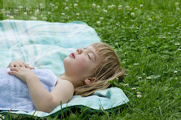 Deutschland  Baden Württemberg  Mädchen schläft auf Picknickdecke auf der Wiese