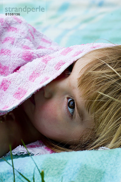 Germany  Baden Wuerttemberg  Girl hiding under towel  close up