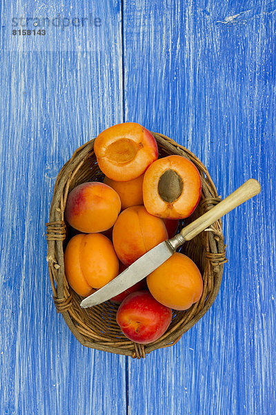 Aprikosen im Korb mit Messer auf dem Tisch  Nahaufnahme