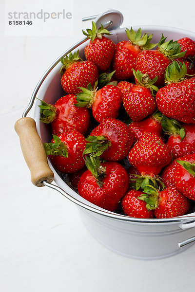 Eimer mit Erdbeeren auf weißem Grund  Nahaufnahme