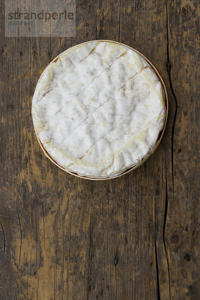Fresh camembert cheese on wooden table  close up