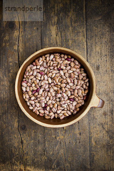Bowl of borlotti beans on wooden table  close up