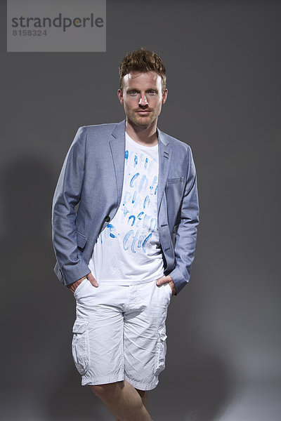 Portrait of mid adult man with business jacket and Bermuda Shorts