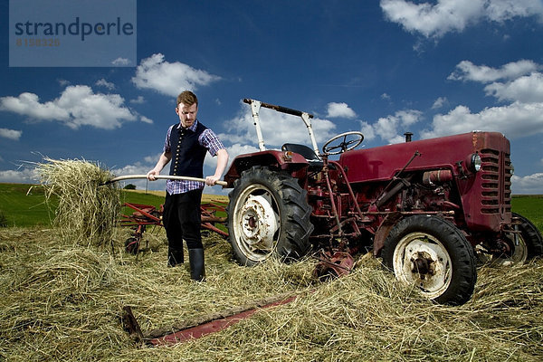 Germany  Bavaria  Farmer with rake in field