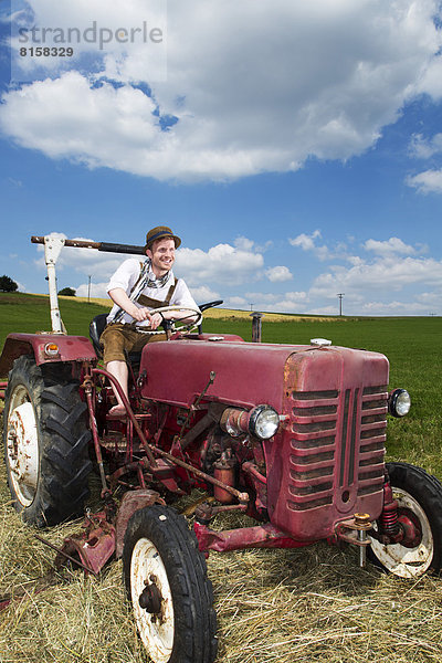 Germany  Bavaria  Farmer in tractor  smiling