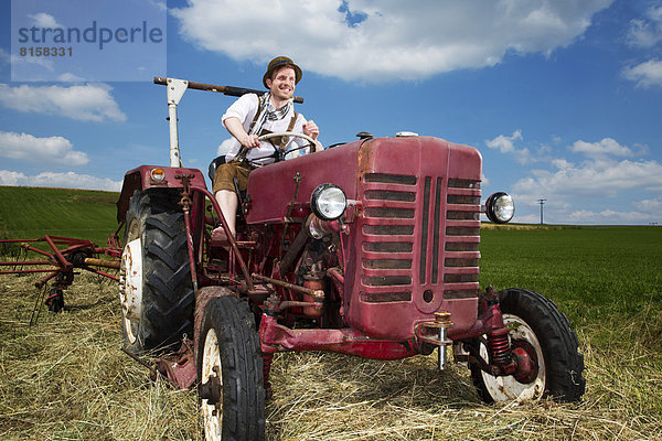 Germany  Bavaria  Farmer in tractor  smiling