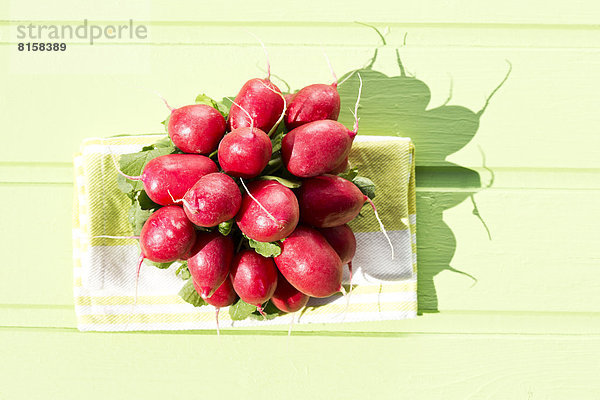 Bunch of red radishes on wooden table  close up