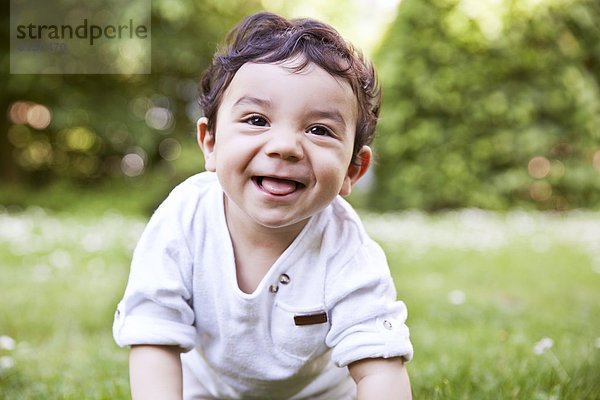 Baby boy crawling on grass  smiling