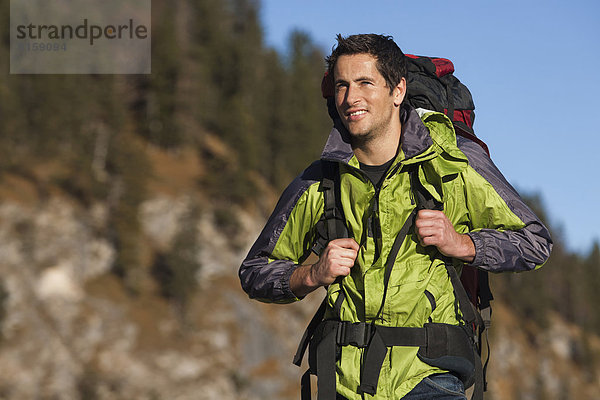 Germany  Mid adult man walking in alps  smiling