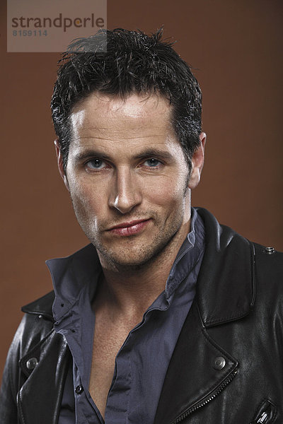 Mid adult man wearing leather jacket  portrait  close up