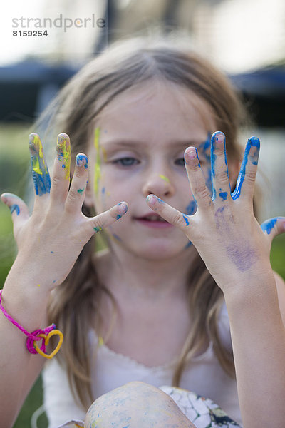 Girl playing with finger paint  close up