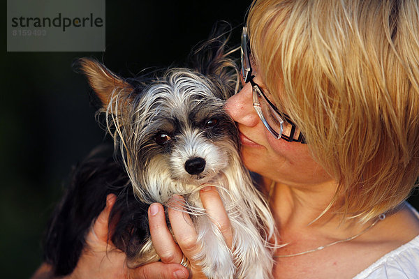 Deutschland  Baden Württemberg  Frau kuschelt chinesischen Schopfhund  Nahaufnahme