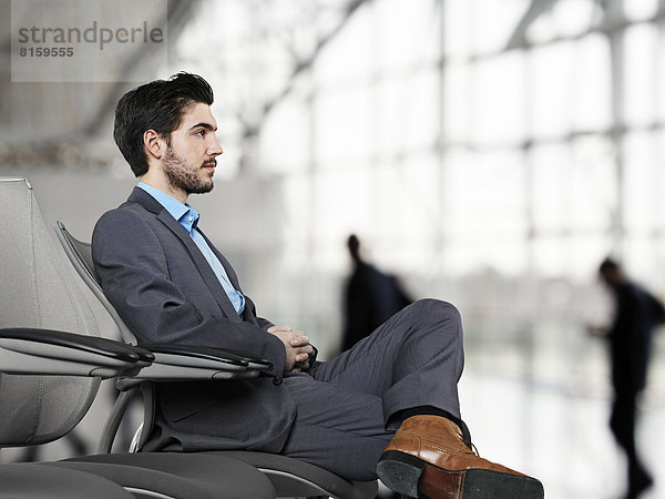 Geschäftsmann wartet am Flughafen  schaut weg