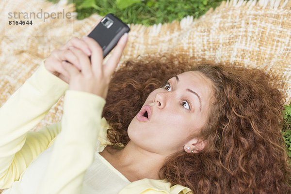 liegend  liegen  liegt  liegendes  liegender  liegende  daliegen  benutzen  Frau  Handy  Telefon  Gras