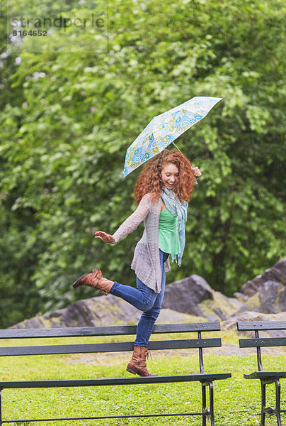 Frau  Regenschirm  Schirm  tanzen  Sitzbank  Bank