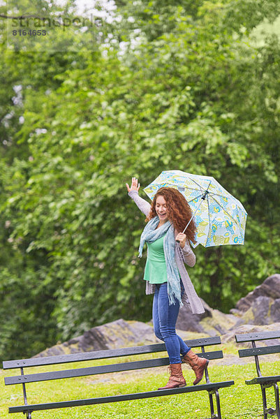 Frau  Regenschirm  Schirm  tanzen  Sitzbank  Bank