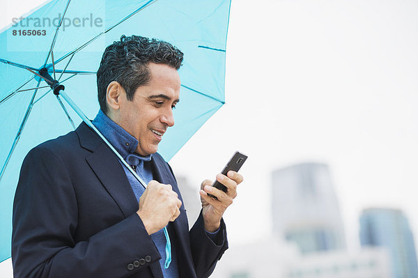 benutzen  Portrait  Mann  Handy  Regenschirm  Schirm  Telefon  halten  blau