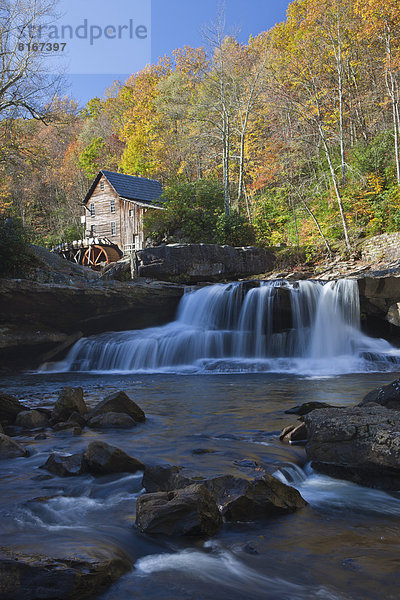 Old mill by small river  waterfall in foreground