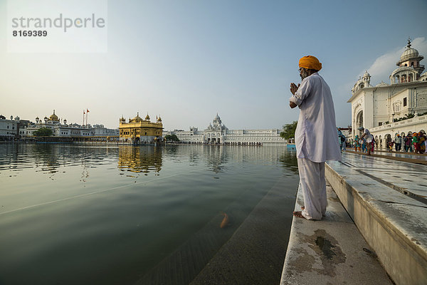 Ein gläubiger Sikh betet am heiligen Teich  Harmandir Sahib oder Goldener Tempel  wichtigstes Heiligtum der Sikhs