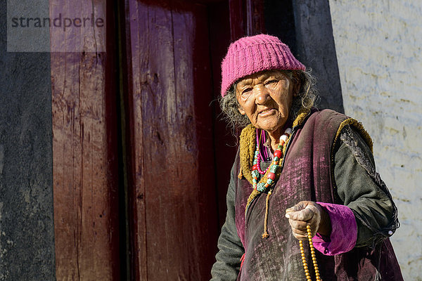 Eine alte Frau aus Ladakh hälte ihre mala  buddhistische Gebetskette  Kloster Lamayuru Gompa