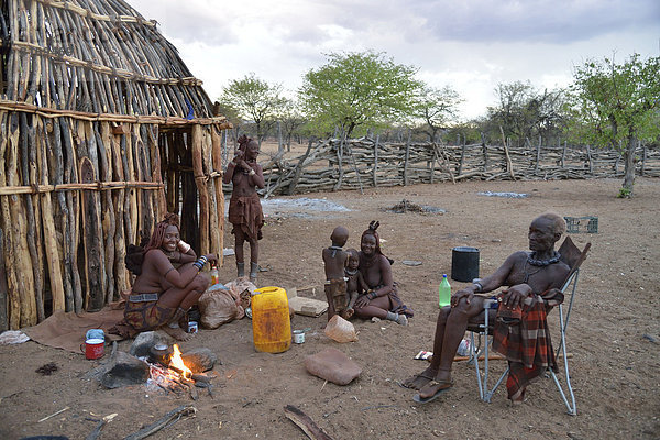 Chief Hikuminue Kapika  der Oberste der namibischen Himba  mit seiner Familie am Feuer in seinem Kral