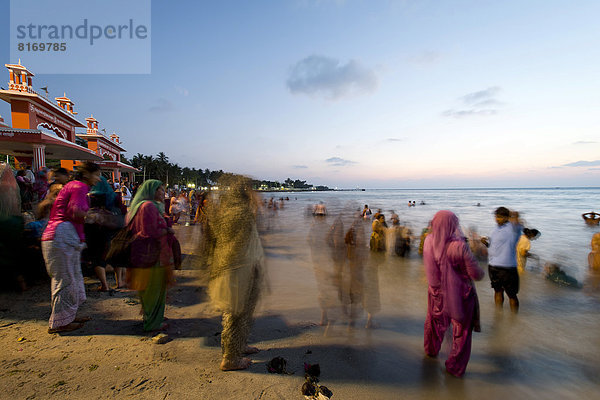 Hindu-Pilger nehmen vor Sonnenaufgang ein heiliges Bad im Meer am Ghat Agni Theertham