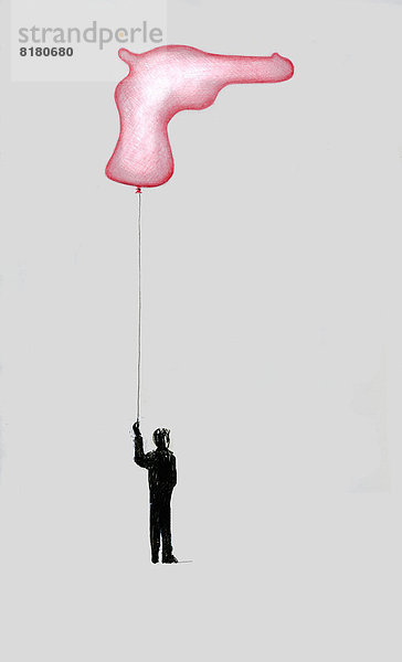 Junge hält Luftballon in Form einer Waffe