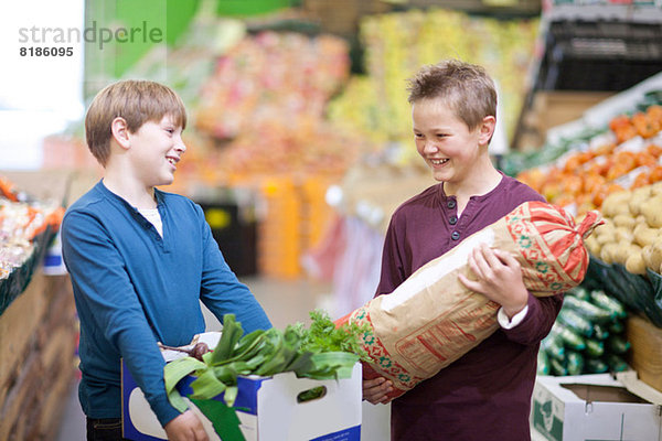 Junge Jungen mit Gemüse auf dem Marktplatz