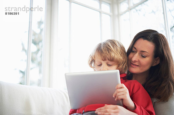 Mutter und Sohn auf dem Sofa mit digitalem Tablett