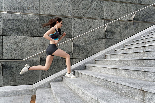 Junge Frau rennt die Treppe hinauf
