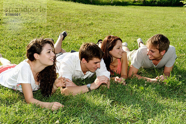 Gruppe junger Erwachsener auf dem Rasen liegend