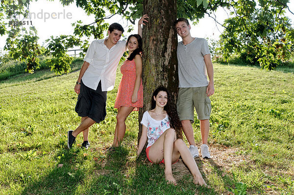 Porträt junger Erwachsener neben einem Baum