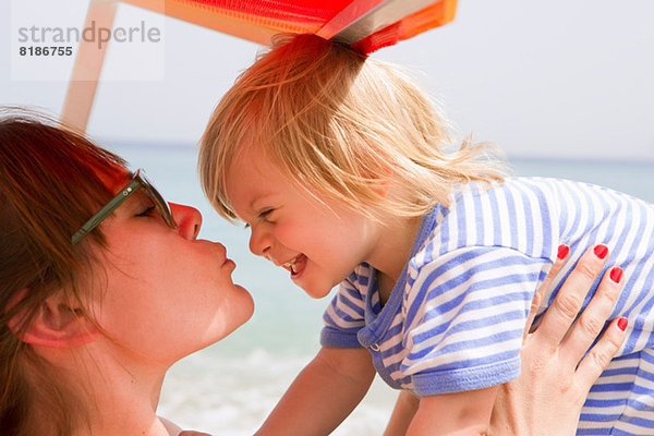 Mutter küsst Baby am Strand