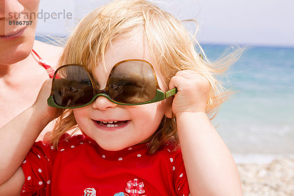 Mädchen mit Sonnenbrille verkehrt herum