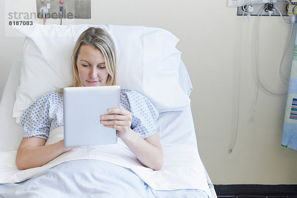 Patient auf dem Krankenhausbett liegend mit digitalem Tablett