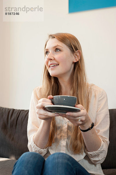 Porträt einer jungen Frau mit Kaffeetasse im Café