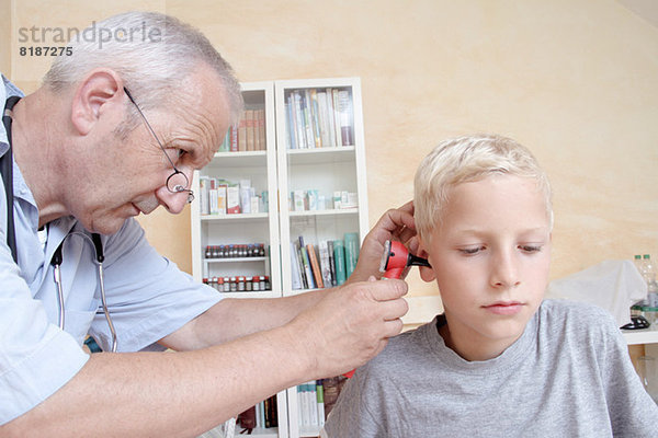 Arzt untersucht das Ohr des Jungen