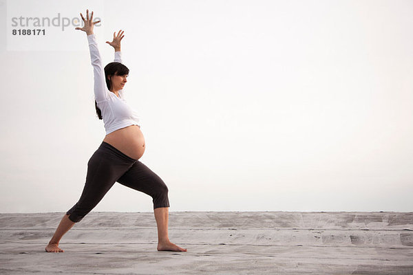 Schwangere Frau in Yoga-Kriegerpose