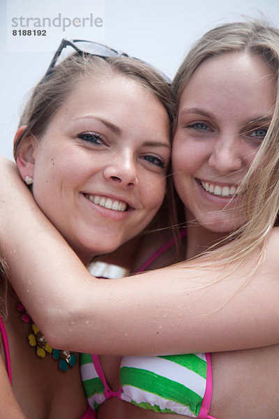Junge Frauen umarmen und lächeln  Nahaufnahme