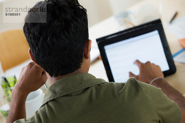 Männlicher Büroangestellter mit Touchscreen auf digitalem Tablett