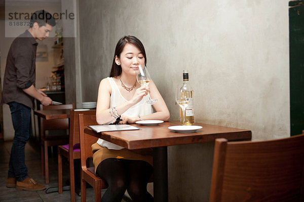 Junge Frau mit Weinglas im Restaurant