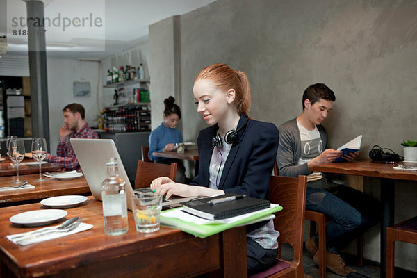 Junge Frau mit Laptop im Café