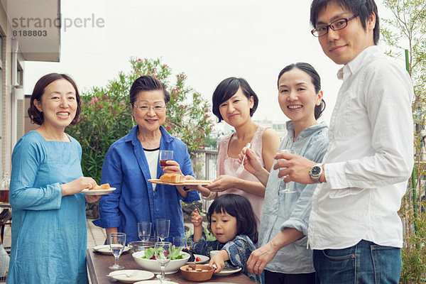 Drei Generationen Familie beim Essen im Freien  Portrait
