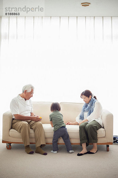 Junge mit Mutter und Großvater auf Sofa