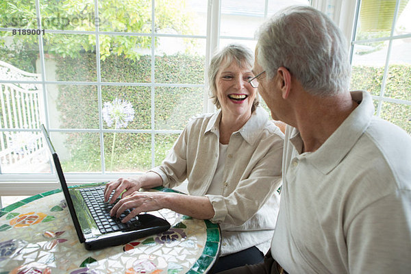 Senior Paar mit Laptop im Wintergarten