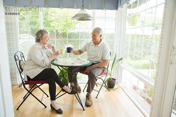 Seniorenpaar bei Tisch im Wintergarten