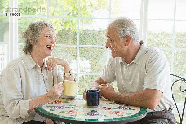 Seniorenpaar bei Tisch im Wintergarten