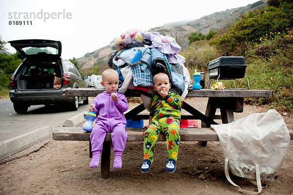 Kleinkind Zwillinge essen Banane auf Picknickbank