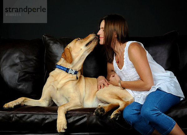 Portrait von Labrador Retriever und Besitzer auf Sofa